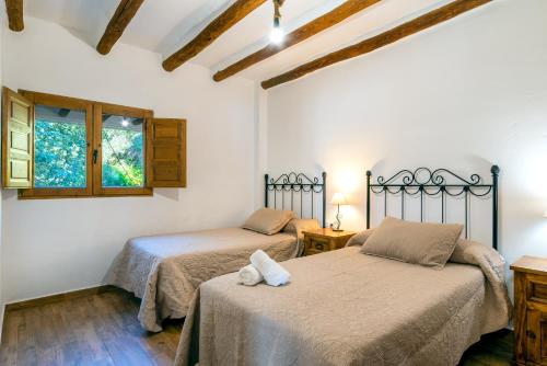 a bedroom with two beds and a window at Dreams Alpujarra in Pampaneira