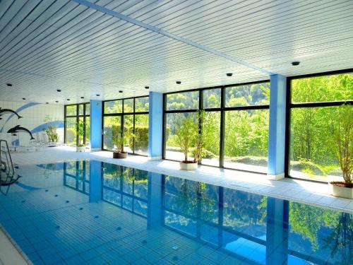 a large swimming pool in a building with windows at Ferienwohnung 424 mit Hallenbad in Bad Reichenhall