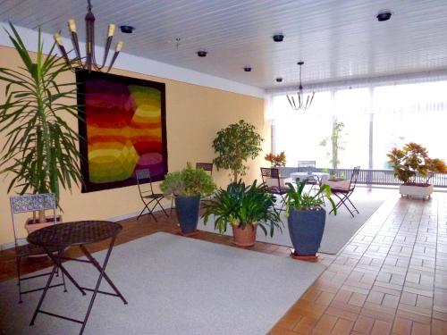 a room with potted plants and a large painting on the wall at Ferienwohnung 424 mit Hallenbad in Bad Reichenhall