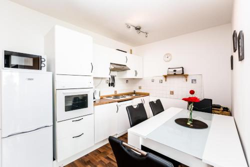 una cucina con armadi bianchi e tavolo e sedie bianchi di Cologne Fair Apartment with Cathedral View a Colonia