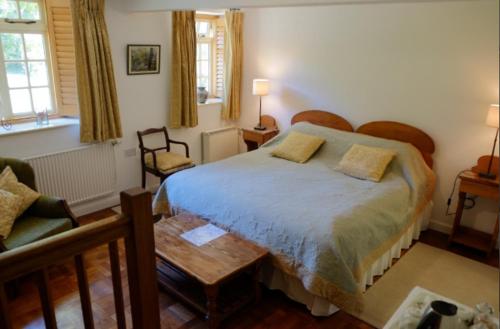um quarto com uma cama grande e um sofá em Bagnell Farm Cottage em Chiselborough