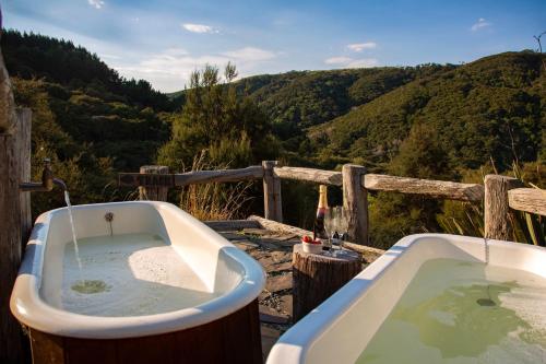 a bath tub sitting next to a wooden fence at Cascade Creek Retreat - near Dunedin in Milton