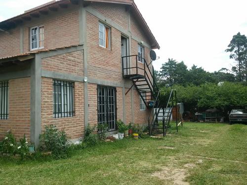 una casa de ladrillo con una escalera en el lateral de ella en Casa de Vero en Mina Clavero