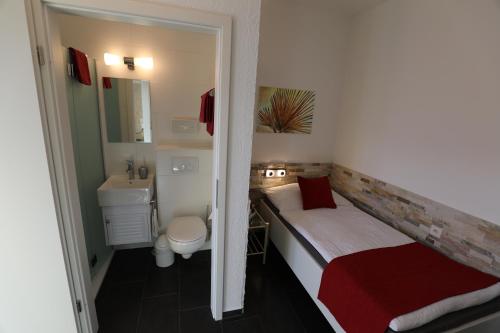 - une petite salle de bains avec un lit et un lavabo dans l'établissement Hotel Garni Morettina, à Brissago