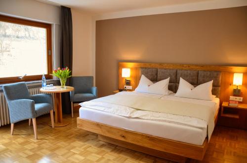 a bedroom with a large bed and a table and chairs at Pension Burk in Bad Endbach