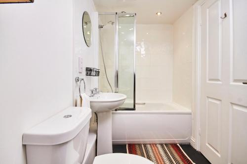 y baño blanco con lavabo, aseo y bañera. en Newcastle Treasure - sleeps 4, en Newcastle