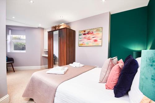 a bedroom with a large bed with a green wall at Newcastle Treasure - sleeps 4 in Newcastle upon Tyne