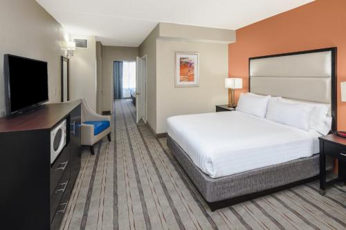 a hotel room with a bed and a flat screen tv at Holiday Inn Express & Suites Atlanta NE- Duluth by IHG in Duluth