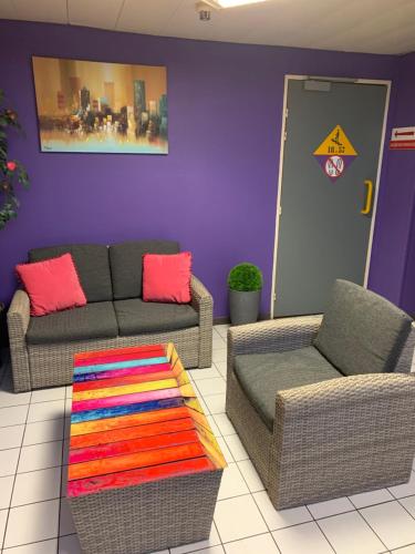a living room with two couches and a colorful rug at Europe Hôtel in Varennes Vauzelles