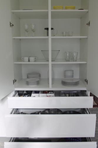 a white cabinet with plates and glasses on it at Sun House in Cascais