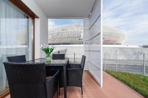 a dining room with a table and chairs on a balcony at Apartments Supernova near Tauron Arena by Renters in Krakow