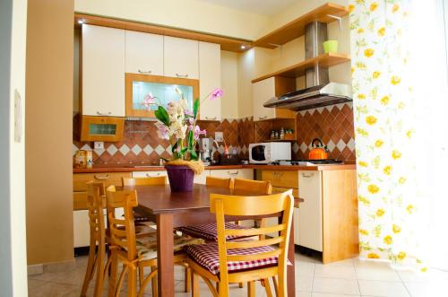 een keuken met een houten tafel en stoelen bij Villa longardi in Zafferana Etnea