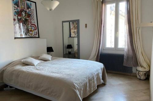 um quarto com uma cama e uma grande janela em Nid douillet t3 au coeur des remparts em Aigues-Mortes