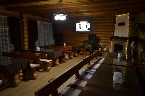 a large room with benches and a tv in it at Sadyba Pikuy in Bilasovytsya