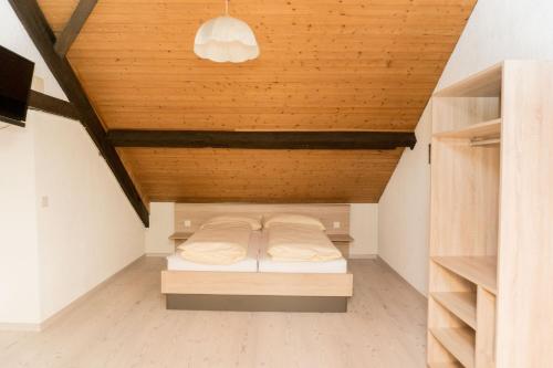 a bed in a room with a wooden ceiling at Speiserestaurant Traube in Küttigen