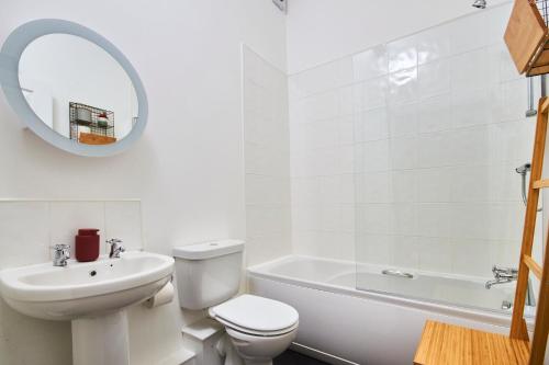 Lovely Abode in Newcastle - Sleeps 4 في نيوكاسل أبون تاين: حمام أبيض مع مرحاض بالوعة ومرآة
