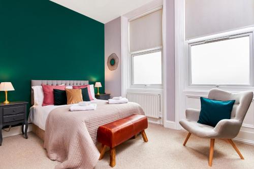 a green bedroom with a bed and a chair at Lovely Abode in Newcastle - Sleeps 4 in Newcastle upon Tyne
