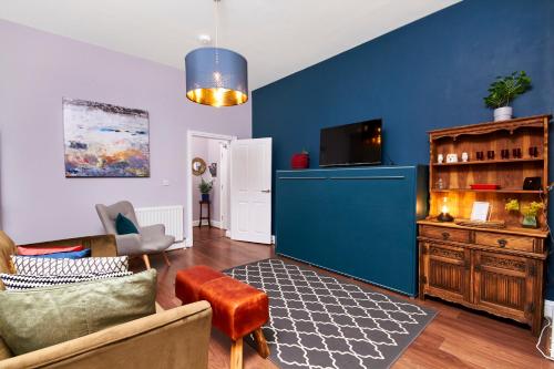 a living room with a blue wall at Lovely Abode in Newcastle - Ground Floor in Newcastle upon Tyne