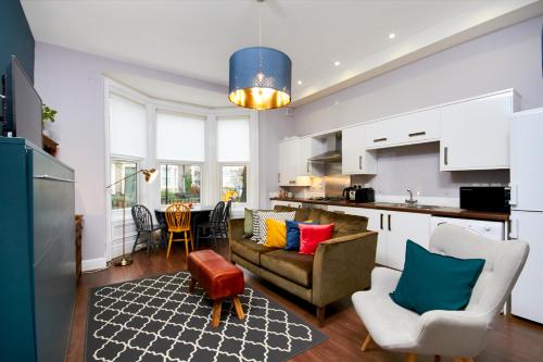 a kitchen and living room with a couch and a table at Lovely Abode in Newcastle - Ground Floor in Newcastle upon Tyne