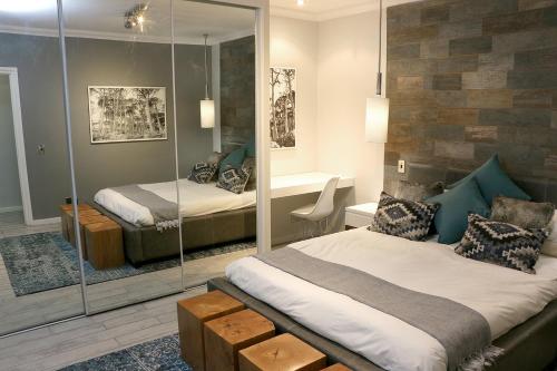a bedroom with two beds and a mirror at Granger Luxury Suites by Totalstay in Cape Town
