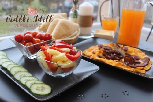 a table topped with plates of food and vegetables at Boutique Vendégház Vidéki Idill Noszvaj in Noszvaj