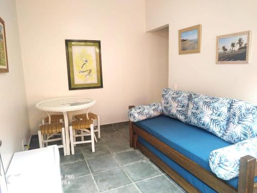 a living room with a blue couch and a table at Pousada Sobre as Pedras in Itanhaém