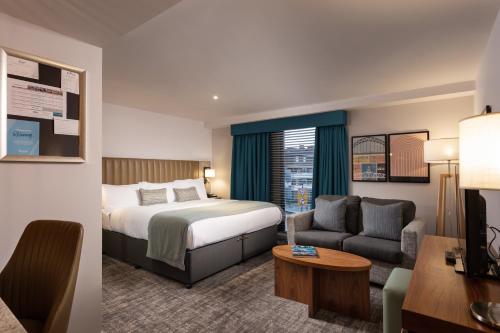 a hotel room with a bed and a couch at Staybridge Suites Newcastle by IHG in Newcastle upon Tyne