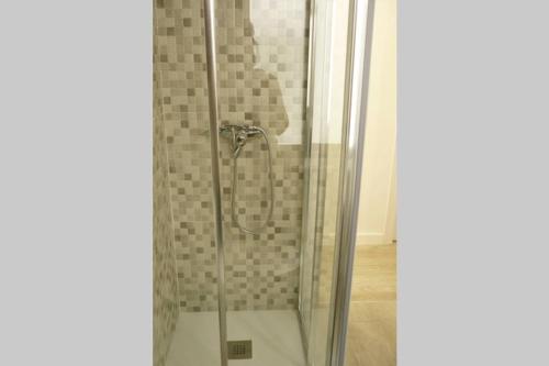 um chuveiro com uma porta de vidro na casa de banho em ÁTICO AUDITORIO disfrute sus 40 metros de terraza orientada al sur em Oviedo