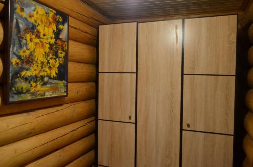 two wooden cabinets in a room with a painting at Sadyba Pikuy in Bilasovytsya