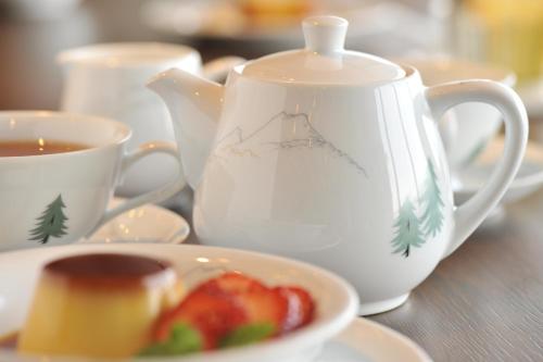 a table with a tea pot and a bowl of fruit at Akakura Kanko Hotel in Myoko