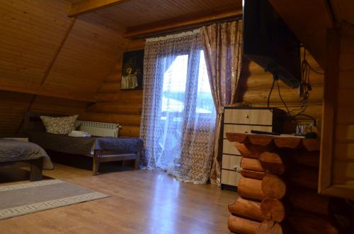 a room with a window in a log cabin at Sadyba Pikuy in Bilasovytsya