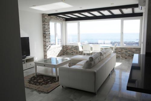 a living room with white furniture and large windows at Luxury Puerto Banus Penthouse With Parking & WI-FI in Marbella