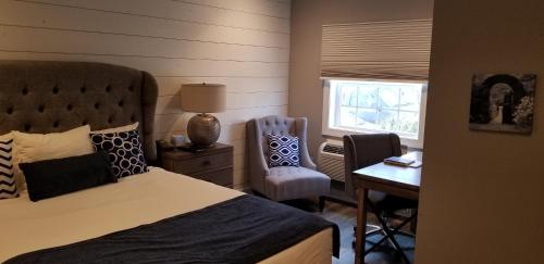 a bedroom with a bed and a desk and a chair at Airlie in Warrenton