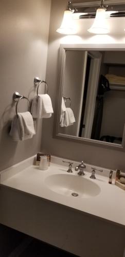 ein Bad mit einem Waschbecken, einem Spiegel und Handtüchern in der Unterkunft Airlie in Warrenton