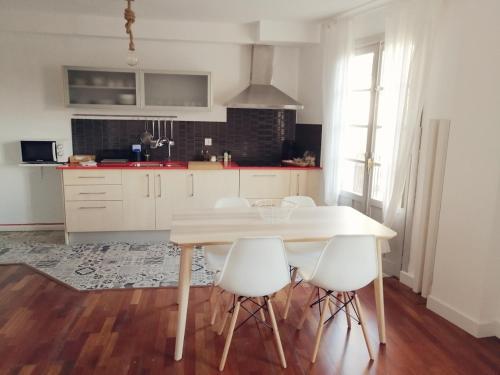 a kitchen with a table and some white chairs at Singular Ronda Apartment in Ronda