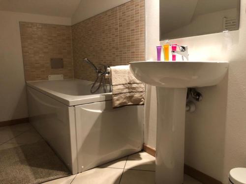 łazienka z umywalką, wanną i toaletą w obiekcie La mansarda w Asti