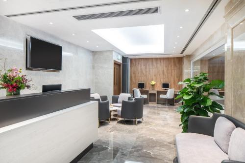 a waiting room with chairs and a flat screen tv at Holiday Inn Macau by IHG in Macau