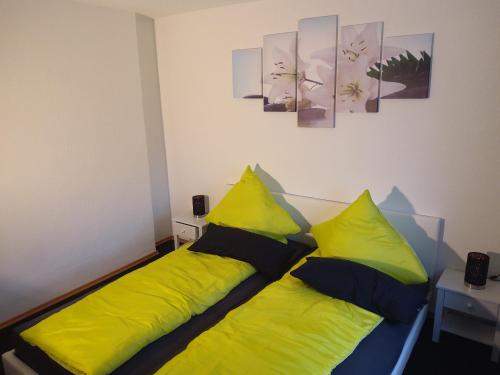 uma cama com almofadas amarelas e pretas num quarto em MTD_Apartment em Weißenthurm