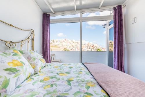 een slaapkamer met een bed en een groot raam bij Duplex BLU VEGUETA in Las Palmas de Gran Canaria