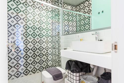 een badkamer met een witte wastafel en een geometrische tegelmuur bij Duplex BLU VEGUETA in Las Palmas de Gran Canaria