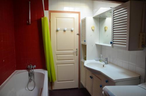 a bathroom with a tub and a sink and a door at Studio et colocation - Gîte Les 7 fontaines in Chevinay