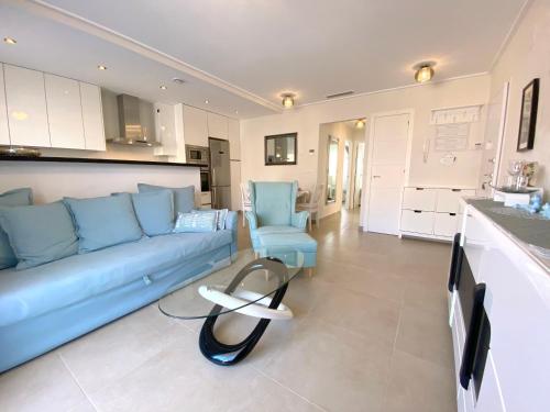 a living room with a blue couch and a kitchen at VISTA AZUL - Punta Prima - SPA y Piscina in Torrevieja
