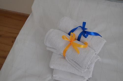 stos ręczników z niebieską i pomarańczową wstążką w obiekcie Apartman 19:14 w mieście Bjelovar