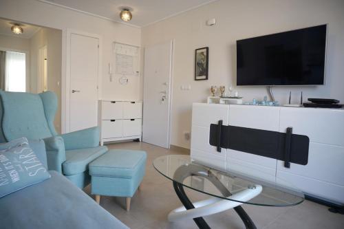 a living room with a couch and a tv at VISTA AZUL - Punta Prima - SPA y Piscina in Torrevieja