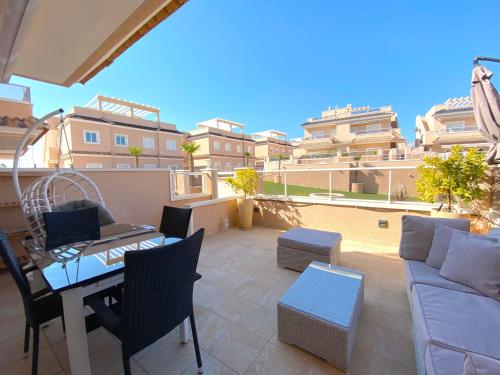 a patio with a couch and a table and chairs at VISTA AZUL - Punta Prima - SPA y Piscina in Torrevieja