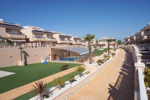 a view of a courtyard with palm trees and buildings at VISTA AZUL - Punta Prima - SPA y Piscina in Torrevieja