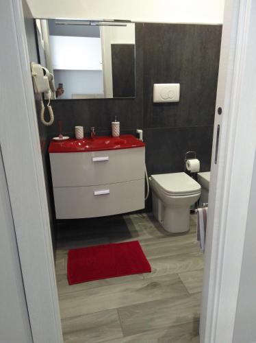 a bathroom with a red sink and a toilet at B&B Nazareth in Barletta