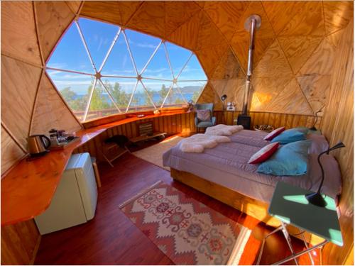a large room with a bed in a yurt at Huiro Lodge in Puerto Corral