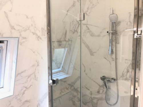 une salle de bain avec une douche avec une porte vitrée dans l'établissement Élégance Haussmanienne, studio moderne et cosy, à Paris