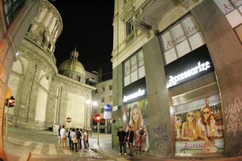 un grupo de personas de pie fuera de un edificio por la noche en dHomes Apart Hotel, en Milán